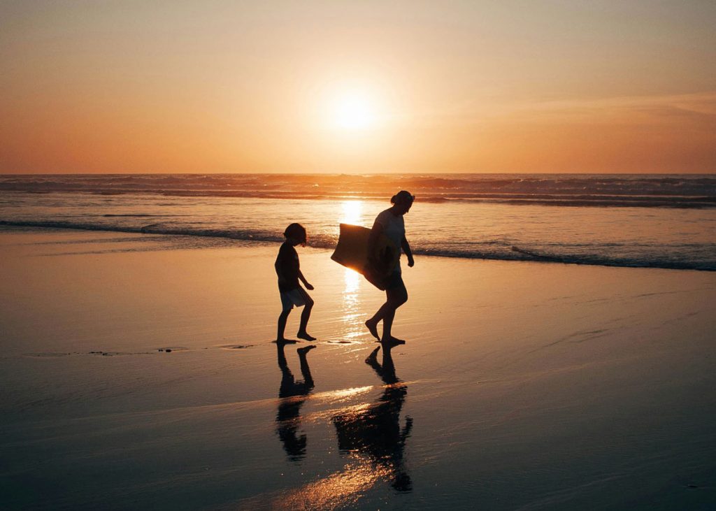 Zwei Kinder am Strand im Sonnenuntergang, gemeinsame Familienzeit und Verbindung