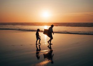 Zwei Kinder am Strand im Sonnenuntergang, gemeinsame Familienzeit und Verbindung