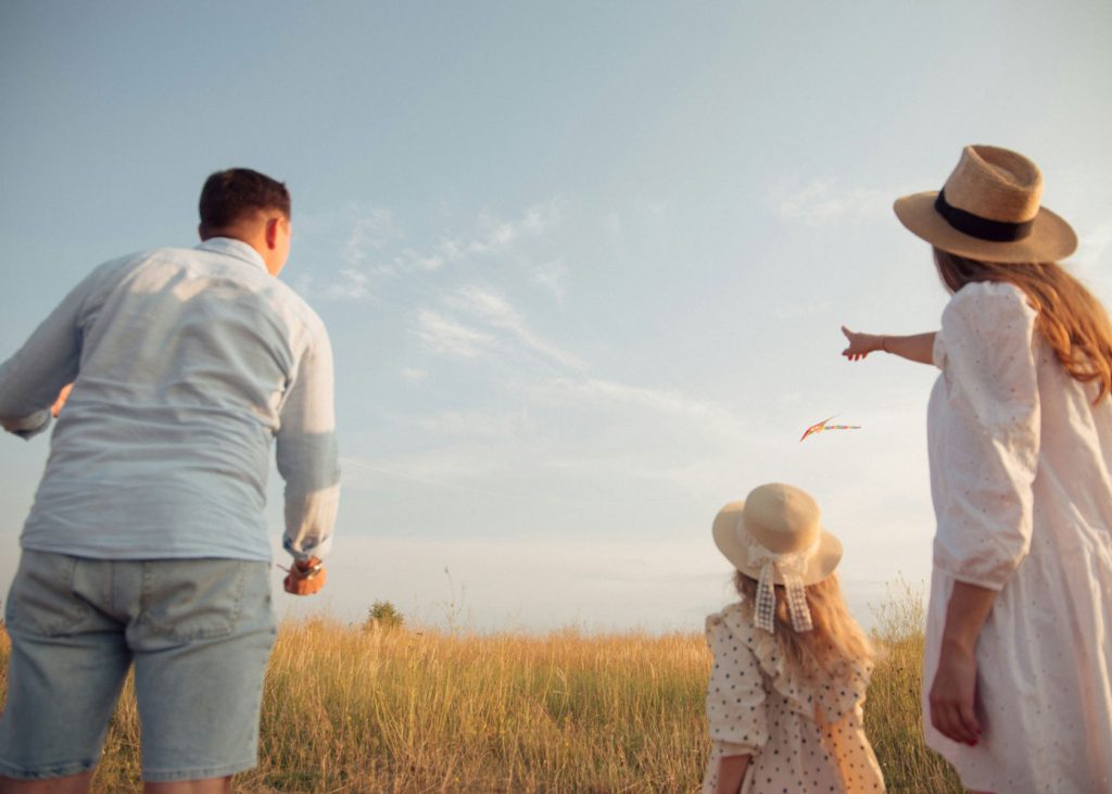Fröhliche Familie beim Spielen am Strand, Leichtigkeit im Familienleben durch Familiencoaching