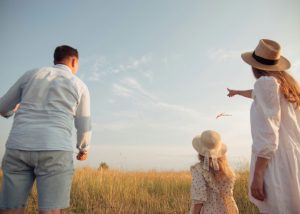 Fröhliche Familie beim Spielen am Strand, Leichtigkeit im Familienleben durch Familiencoaching