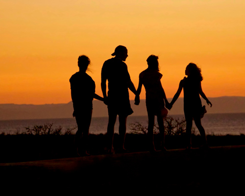 Familie Hand in Hand beim Sonnenuntergang