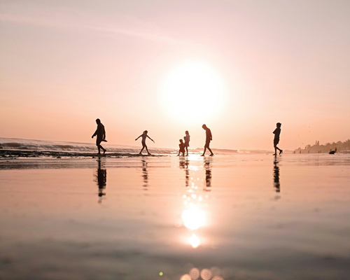 Menschen im Meer bei Sonnenuntergang